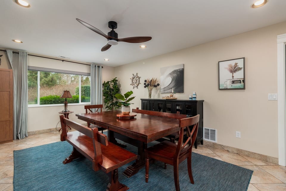 Gather around this welcoming dining table where shared meals become cherished memories, surrounded by coastal charm and garden views.