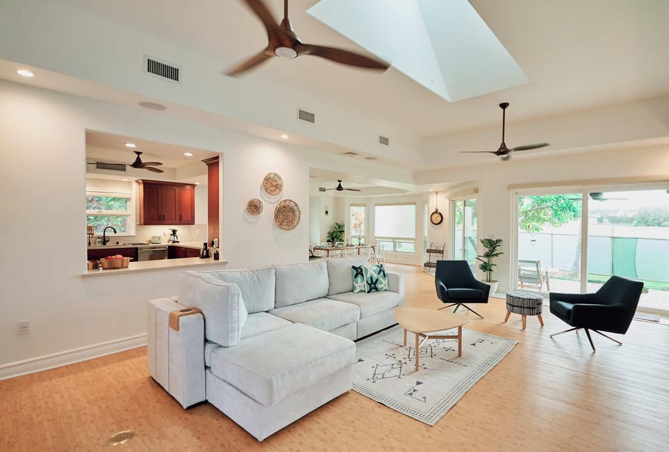 Spacious living room with soaring ceilings, modern furnishings, and seamless flow to the gourmet kitchen.