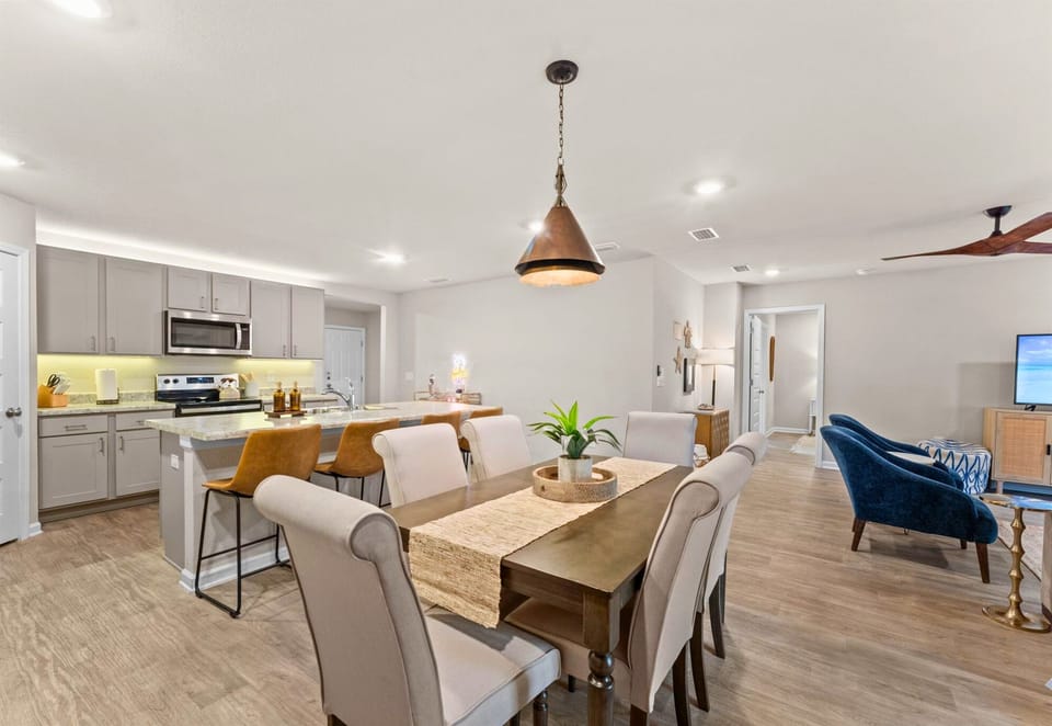 An open view of the dining and living spaces makes the home feel connected, bright, and welcoming.