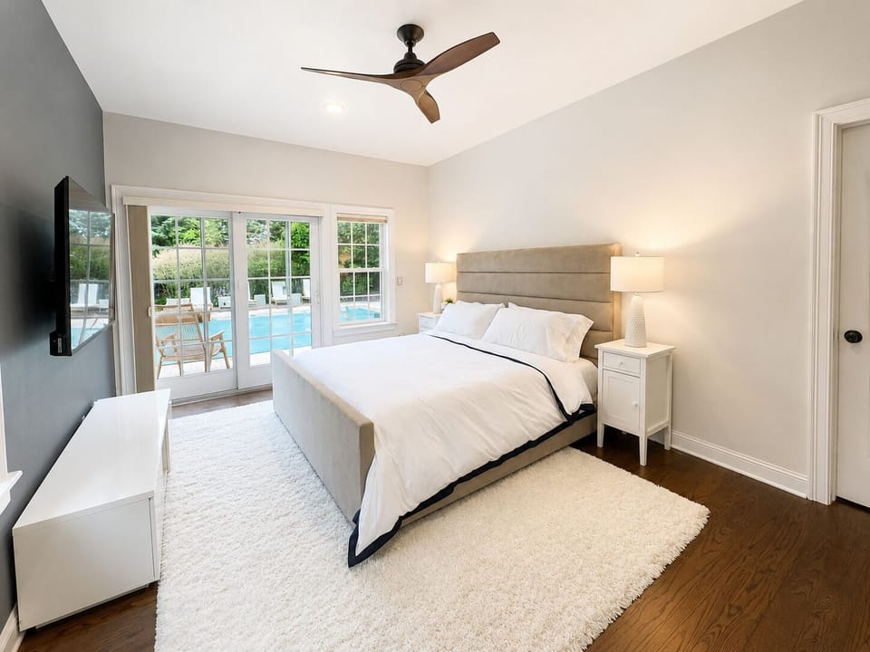 A well-appointed king suite with a smart TV, hardwood floors, and sliding doors 