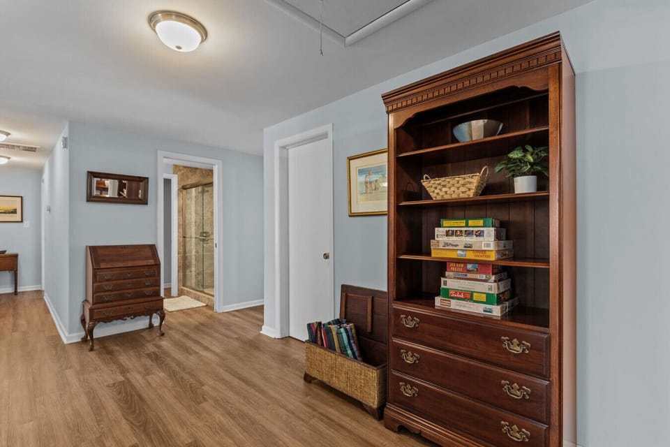 Main hallway providing access to all bedrooms, with puzzles available in the bookcase for guests to enjoy.