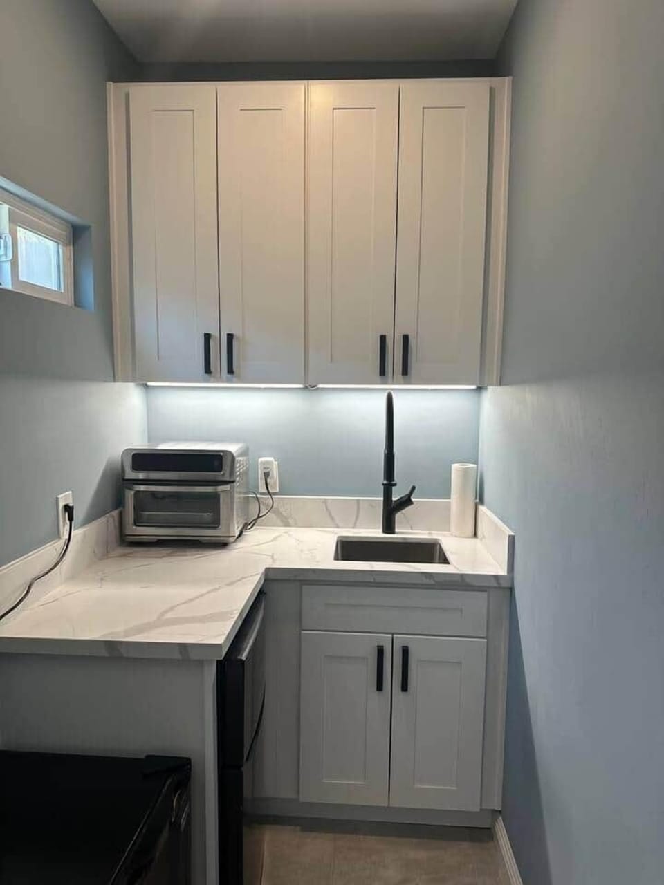 Kitchenette with sink, dishes, fridge and toaster oven