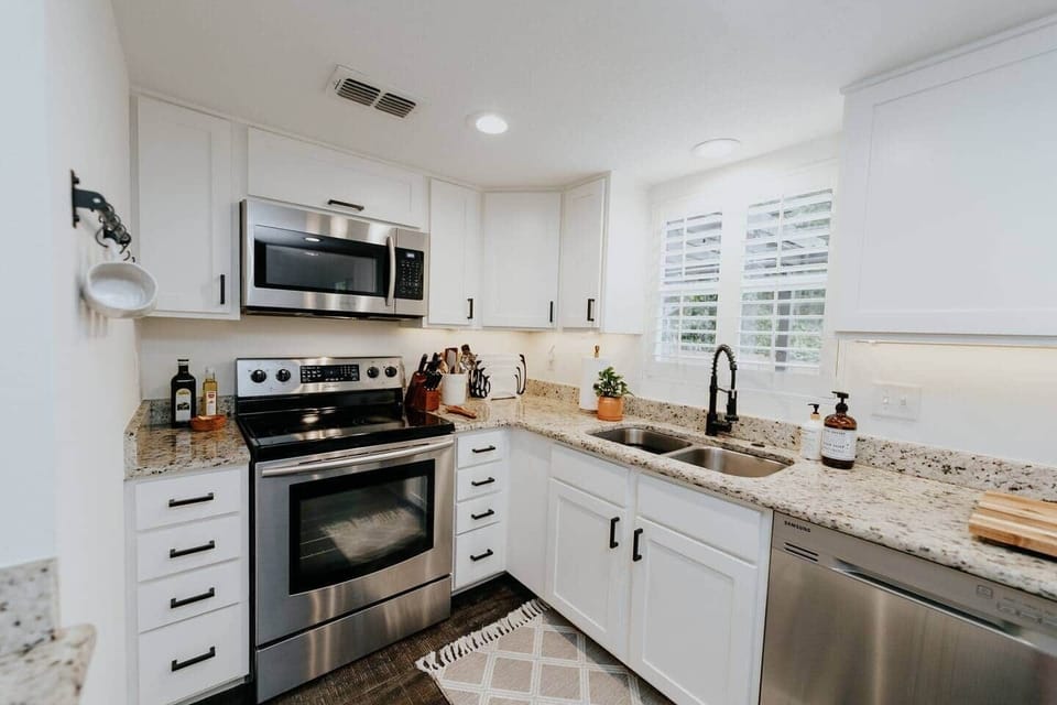Beautifully modern kitchen. Stocked with hand soap, dishwasher and dish soap, and cleaners under the sink. PLENTY of cutting boards and cooking utensils, sharp knives, beautiful dishes and serving ware. 