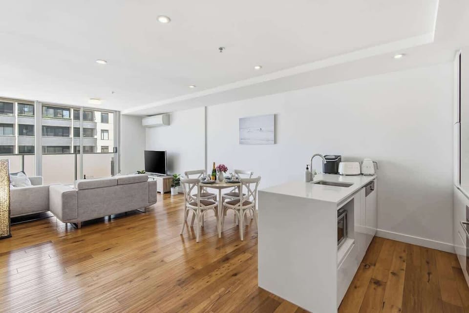 Open plan apartment with modern kitchen, dining and living areas filled with natural light and designed for comfort and convenience.