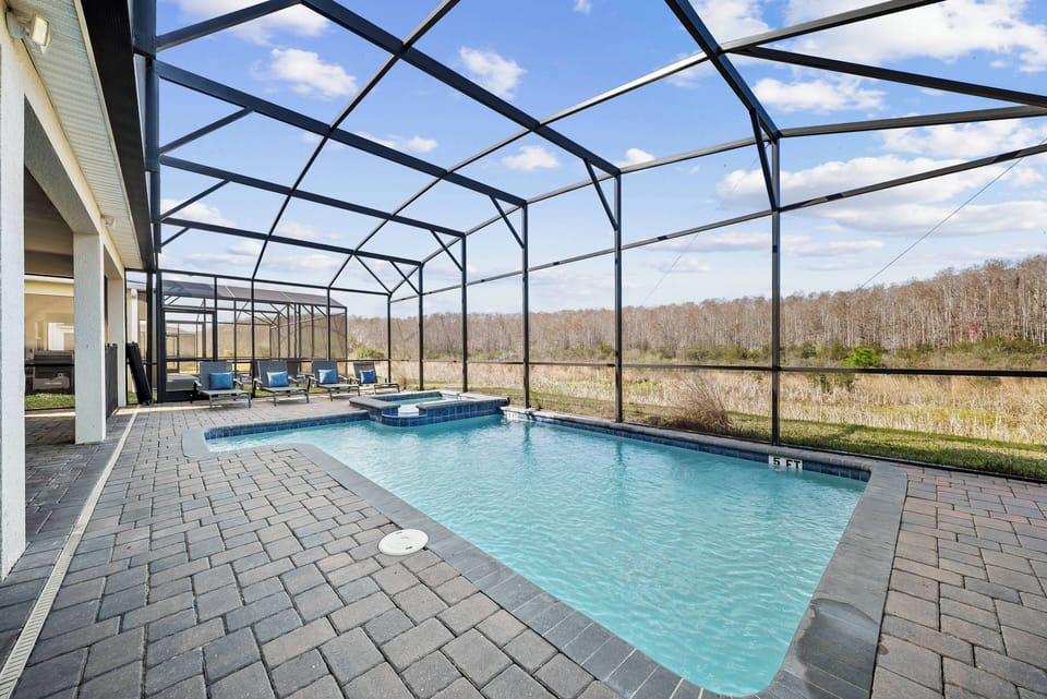 Step outside to your own private oasis featuring a sparkling pool framed by sleek pavers and a spacious lanai. Enjoy breathtaking views of the surrounding landscape through the expansive screens, perfect for sun-soaked relaxation.