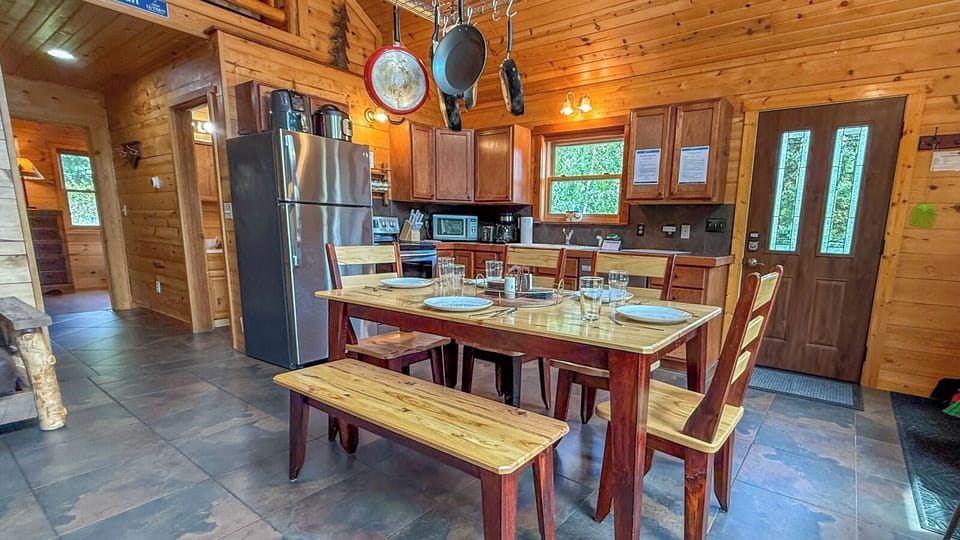 Picture yourself gathered around this rustic farmhouse table, sharing meals and making memories in your cozy mountain cabin with its warm wood beams and fully equipped kitchen ready for your culinary adventures.