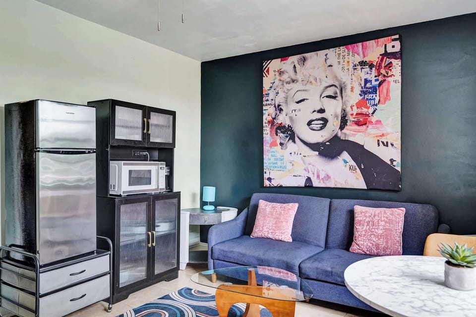 The stylish living room includes a kitchenette, cozy dining table, & smart TV​