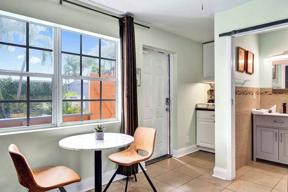 The stylish living room includes a kitchenette, cozy dining table, & smart TV​