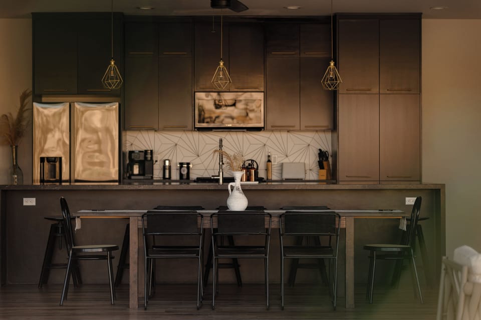 Modern kitchen with dining table, breakfast bar, and sleek designer finishes