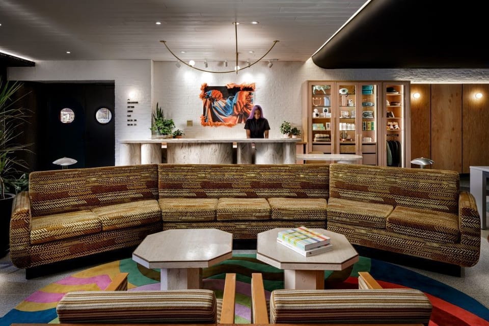 The inviting reception space of The Drake Hotel is filled with eclectic art pieces and cozy seating, reflecting its boutique charm.