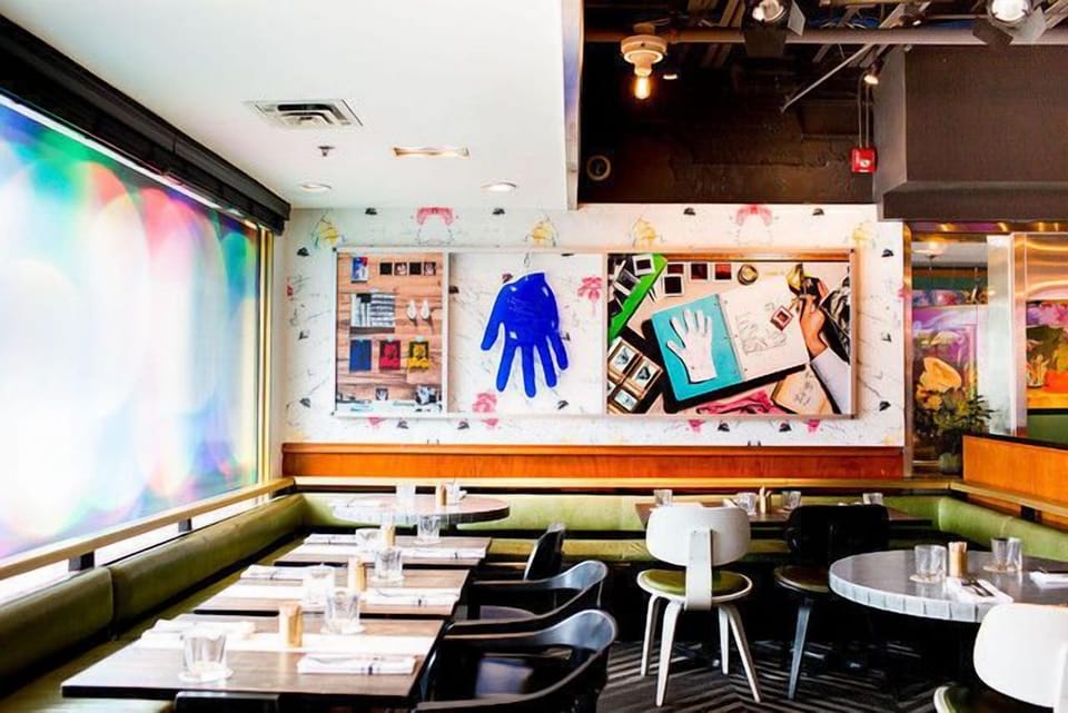 Another stylish dining area in The Drake Hotel features alluring wall art and modern furnishings, exemplifying its artistic spirit.