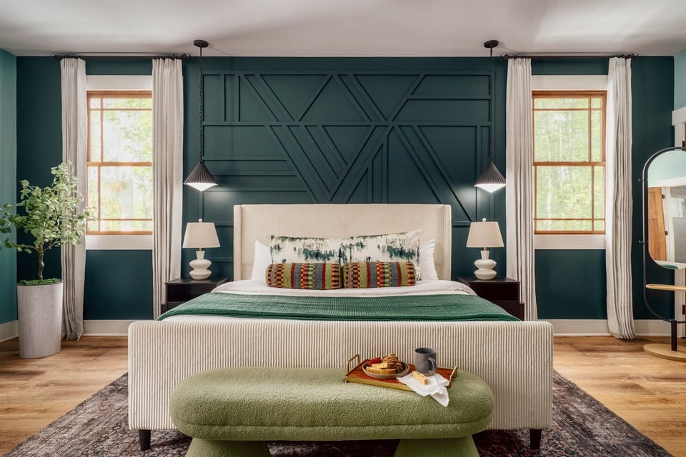 Spa-like primary suite wrapped in deep forest green, with a plush king bed, layered textures, and morning light pouring in—made for slow wakeups, breakfast in bed, and feeling a little bit spoiled every night of your stay.