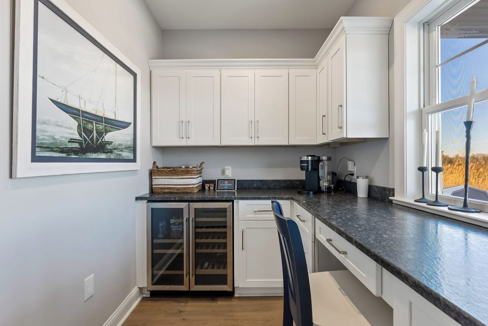 Dedicated Office Space With Coffee Maker and Additional Beverage Fridge Overlooking Pool