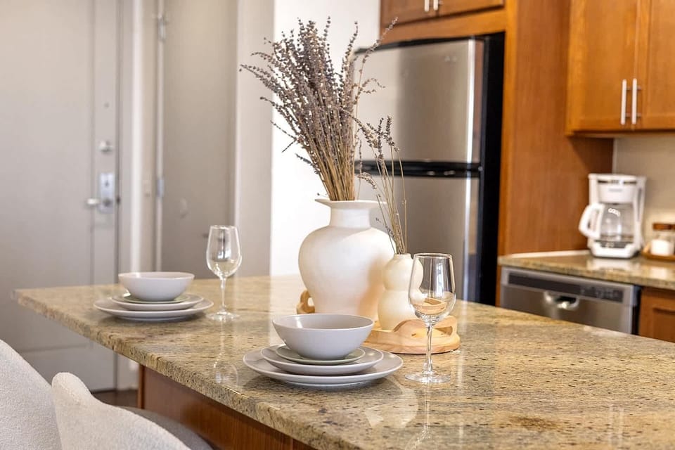 Kitchen connected dining area with granite countertop seating, set for casual meals or morning coffee. A welcoming spot to dine comfortably while staying close to the kitchen workspace.