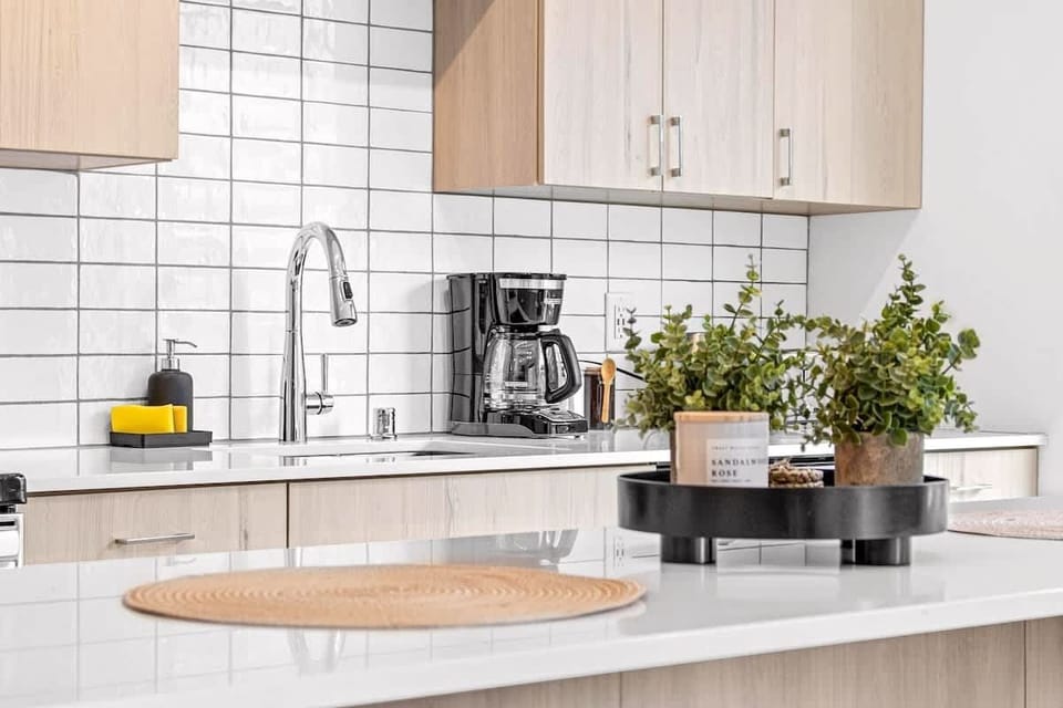 Elegant kitchen island décor featuring modern greenery and neutral accents — a perfect touch of freshness that complements the bright, airy design of this open kitchen space.