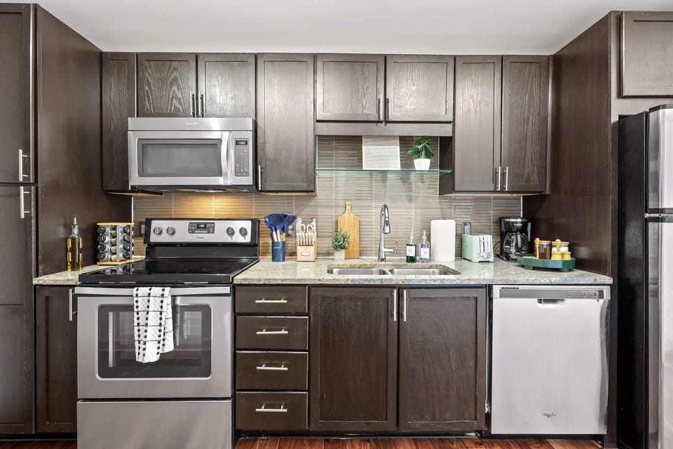 Fully equipped and beautifully designed, this kitchen features sleek dark cabinetry and stainless steel appliances, creating a stylish, welcoming space perfect for cooking, dining, and gathering together. ✨🍽️ 