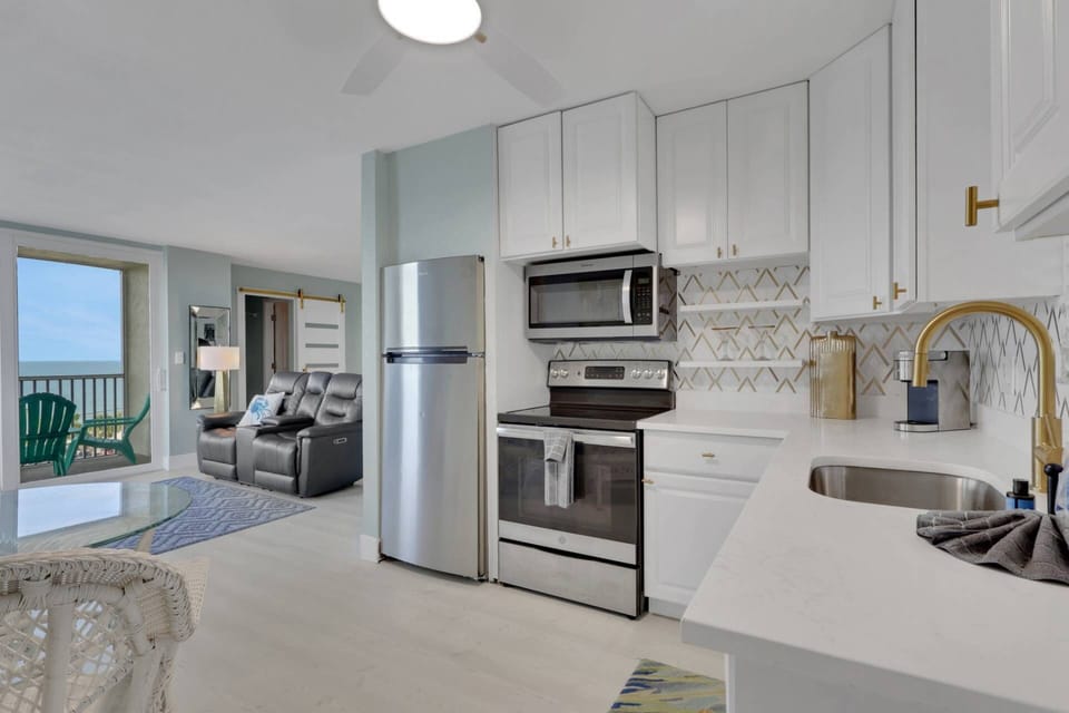 The freshly updated kitchen has a refrigerator/freezer, stove, microwave, and quartz counters.
