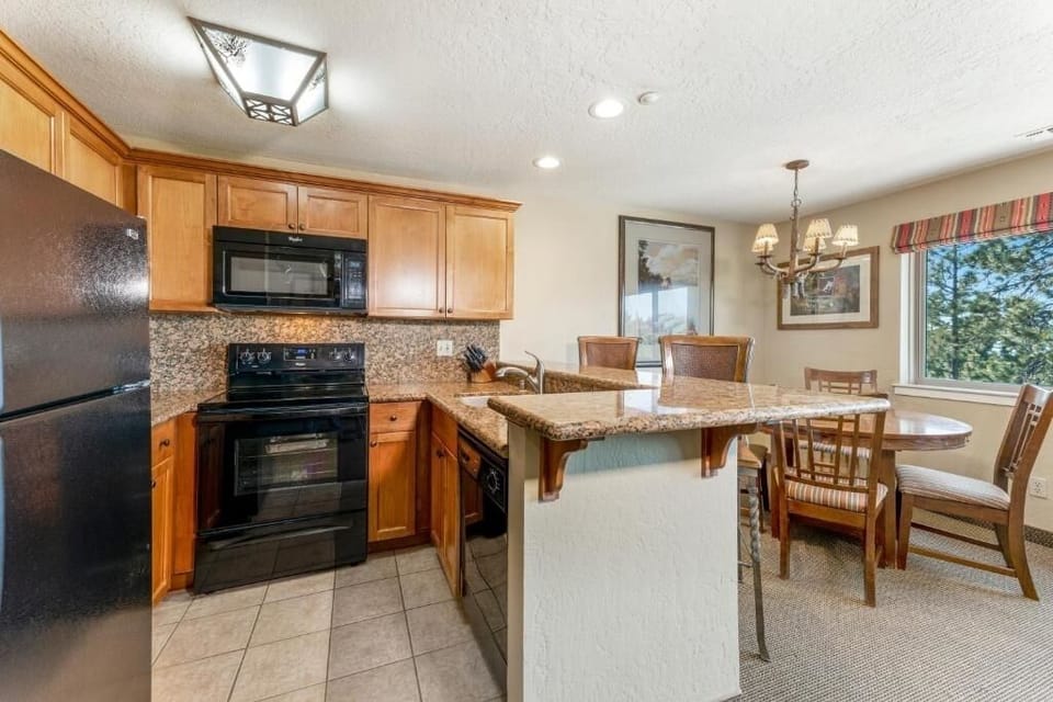Cook and connect in the bright kitchen with granite bar seating.