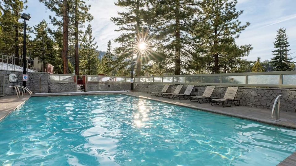 Dive into sunlit mountain serenity beside the sparkling outdoor pool.