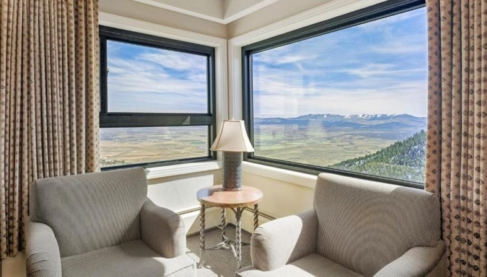 Sip coffee beside corner windows overlooking sweeping mountain scenery