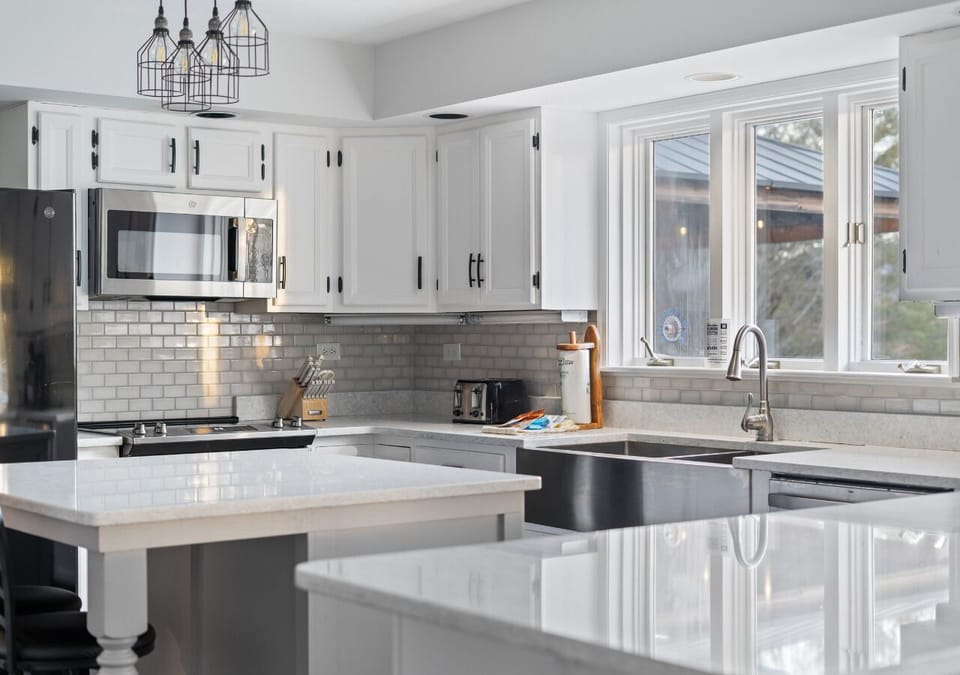 Bright, modern kitchen with white cabinetry, stainless appliances, and generous counter space.