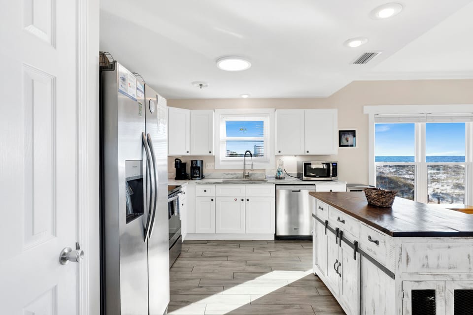 The kitchen features stainless appliances and stone counters