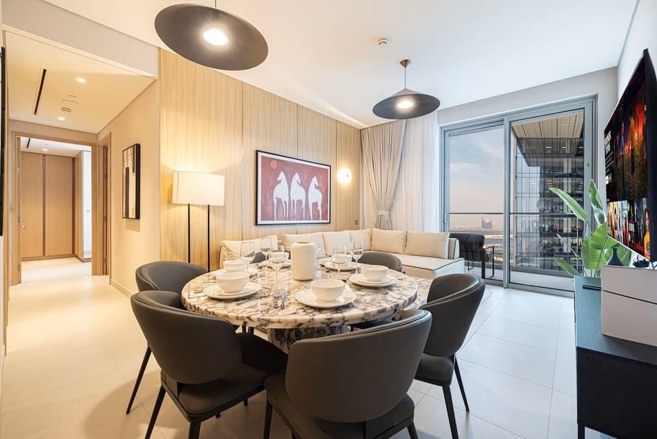 Dine in style with views of the living room and expansive windows framing the city skyline as your backdrop