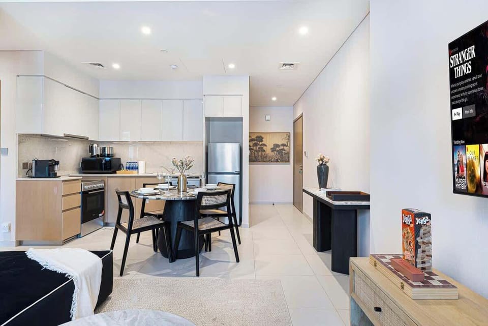 Dine in style at a beautifully set dining table, overlooking the living room and a breathtaking city backdrop through large windows