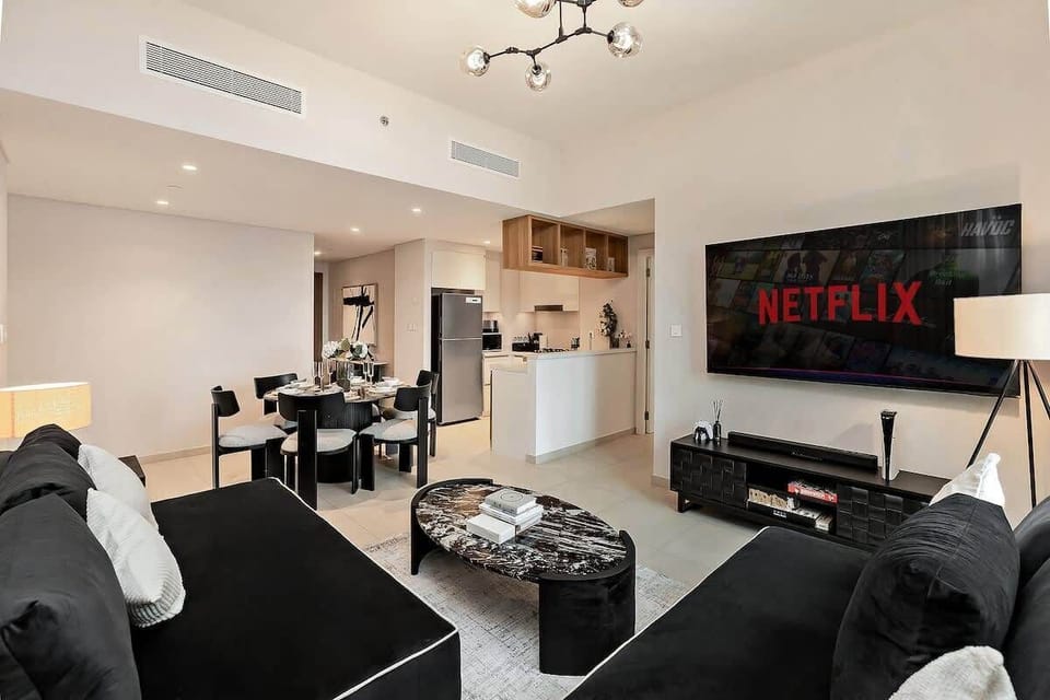Open and airy lounge perfect for evenings in, with a comfy sofa, flat-screen TV, classic games, and iconic city views