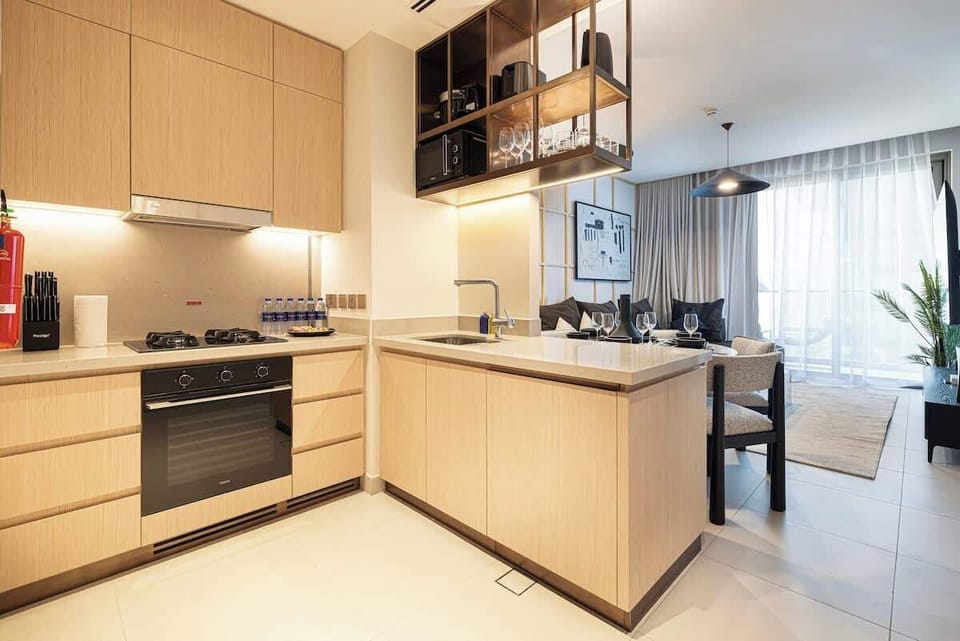 Sunlight floods this open-layout kitchen, highlighting sleek countertops and a clean, modern design—perfect for morning coffee or a leisurely brunch