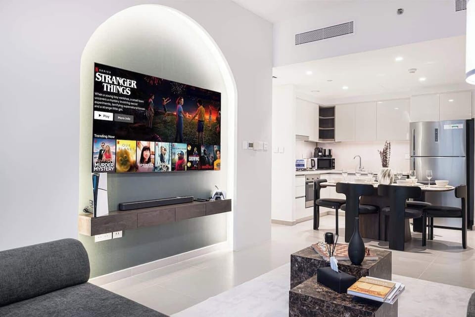 Bright and inviting open-concept living space featuring a cozy lounge area, fully equipped modern kitchen, and a stylish dining