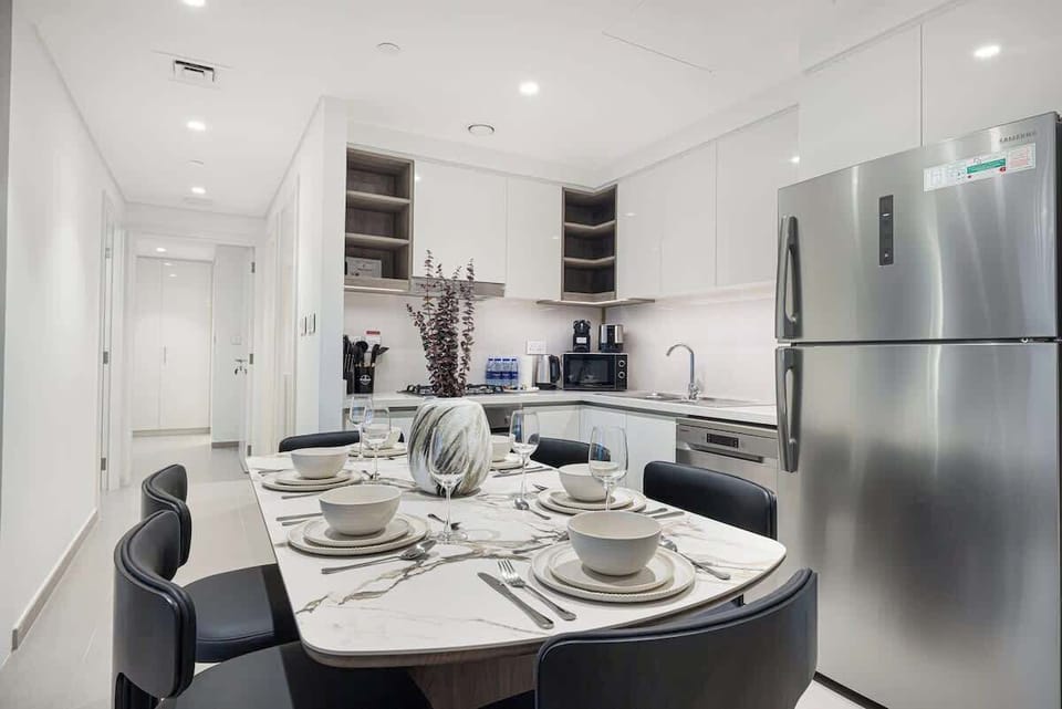 Warm, open-concept room with a full kitchen and elegant dining setup—made for memorable stays