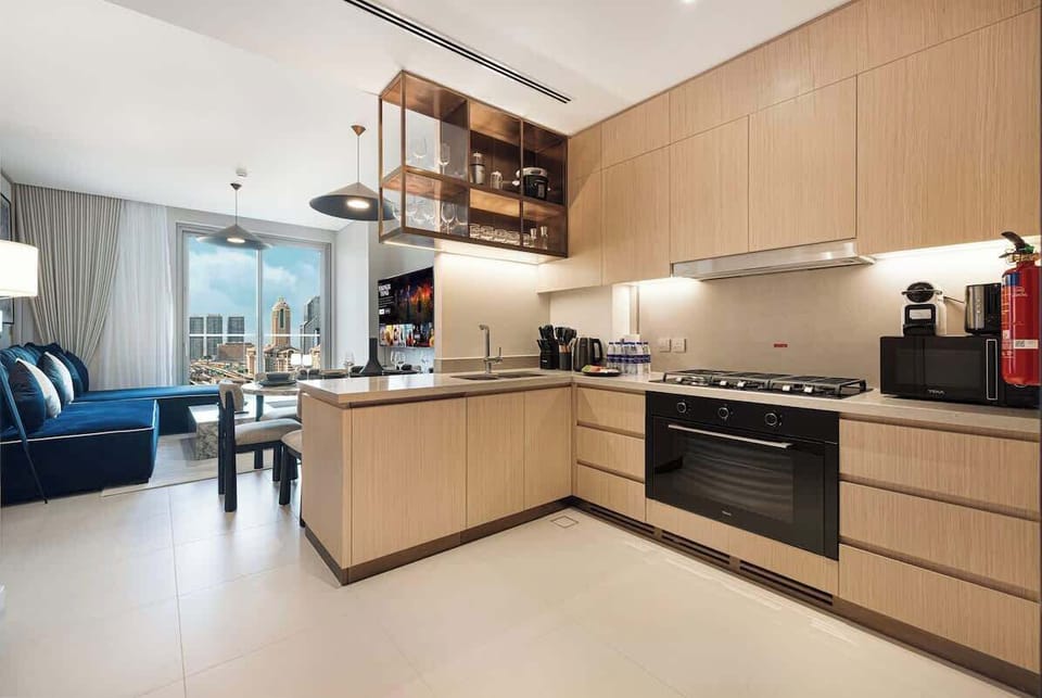 Sunlight floods this open-layout kitchen, highlighting sleek countertops and a clean, modern design—perfect for morning coffee or a leisurely brunch