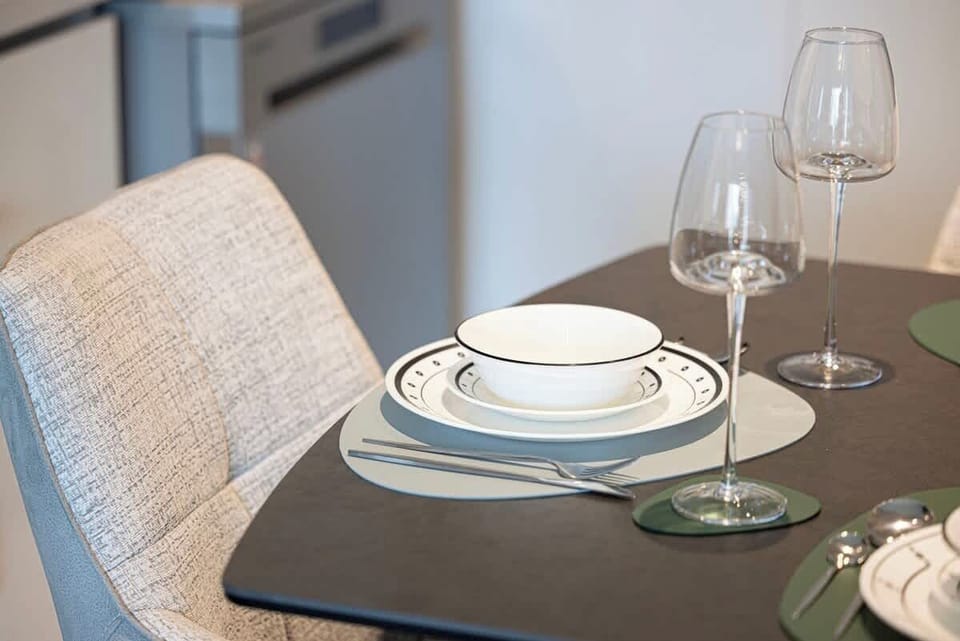 Open dining area with a set table, perfect for meals with views of the living room and spectacular city backdrop