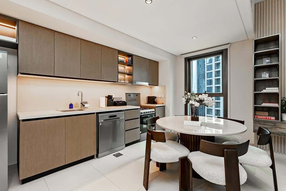 Open-concept kitchen featuring a gas stove and oven, coffee machine, microwave, toaster, and utensils, perfect for home-cooked meals with views of the dining and living rooms