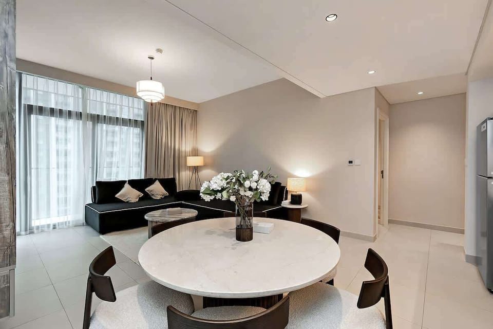 Dine in style at a gorgeous dining table, with open views to the living room and cityscape beyond floor-to-ceiling windows