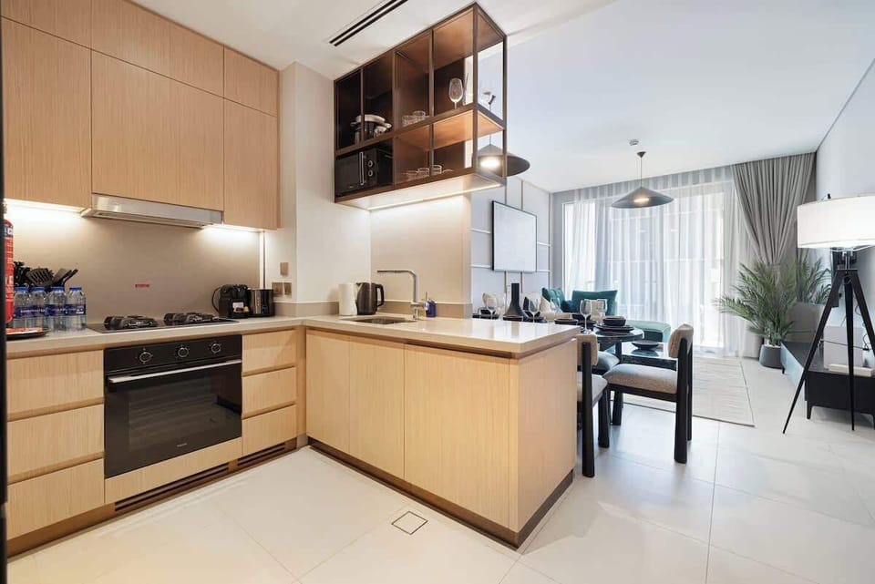 Sunlight floods this open-layout kitchen, highlighting sleek countertops and a clean, modern design—perfect for morning coffee or a leisurely brunch