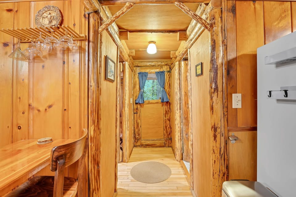 Step into this charming rustic hallway where warm wood surrounds you with cozy cabin vibes and natural beauty.