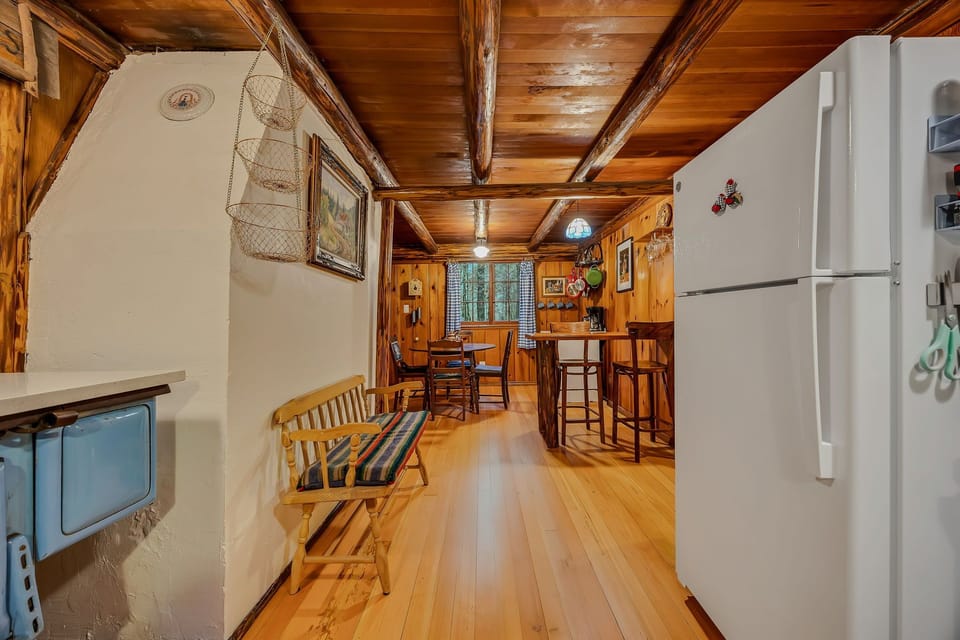 Your charming cabin kitchen welcomes you with rustic wood beams, warm pine walls, and everything needed for cozy meal prep.