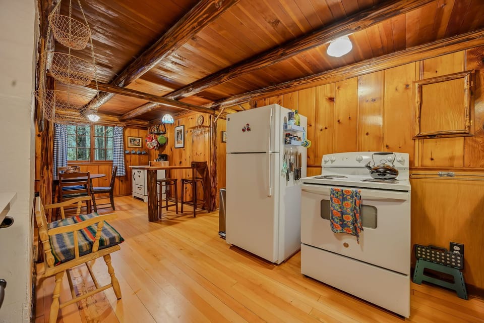 Your rustic kitchen blends charm with convenience, featuring exposed beams, warm wood cabinets, and full appliances for memorable meal prep.