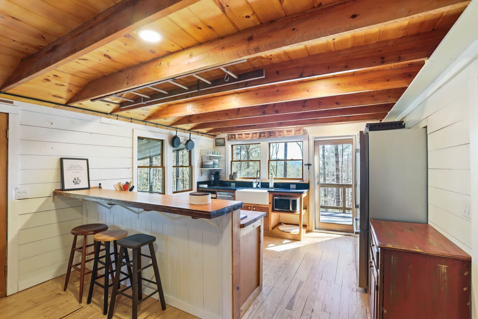 The kitchen hums with quiet joy. You lean against the wood countertop, coffee in hand, watching morning mist lift through the trees. Breakfast is unhurried, conversation easy. Here, time stretches and the view out every window reminds you—you’re exactly where you need to be.