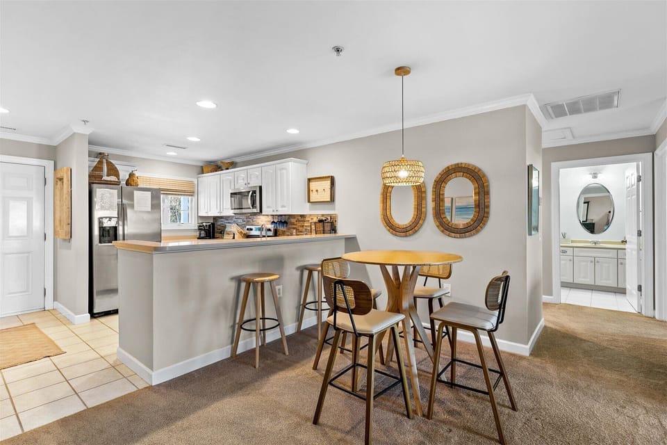 Your open-concept kitchen flows seamlessly into the dining area, featuring modern appliances and warm coastal accents for memorable meals together.