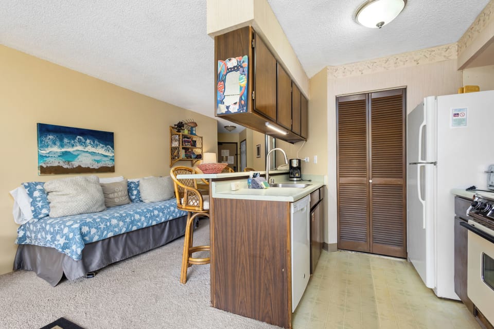 Your cozy studio blends comfort and convenience, with a coastal-inspired daybed, breakfast bar with seating, and a full kitchenette featuring all the essentials for easy meal prep during your stay.