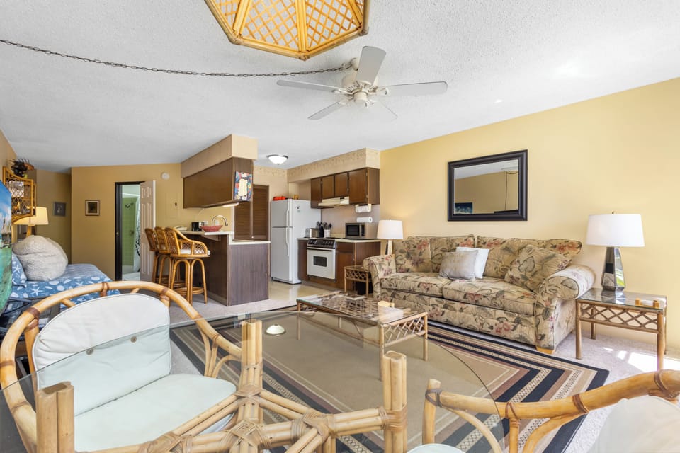 Your open-concept living space blends kitchen, dining, and lounge areas with tropical-inspired décor, bamboo accents, and a warm, inviting atmosphere perfect for relaxing after a day of adventure.