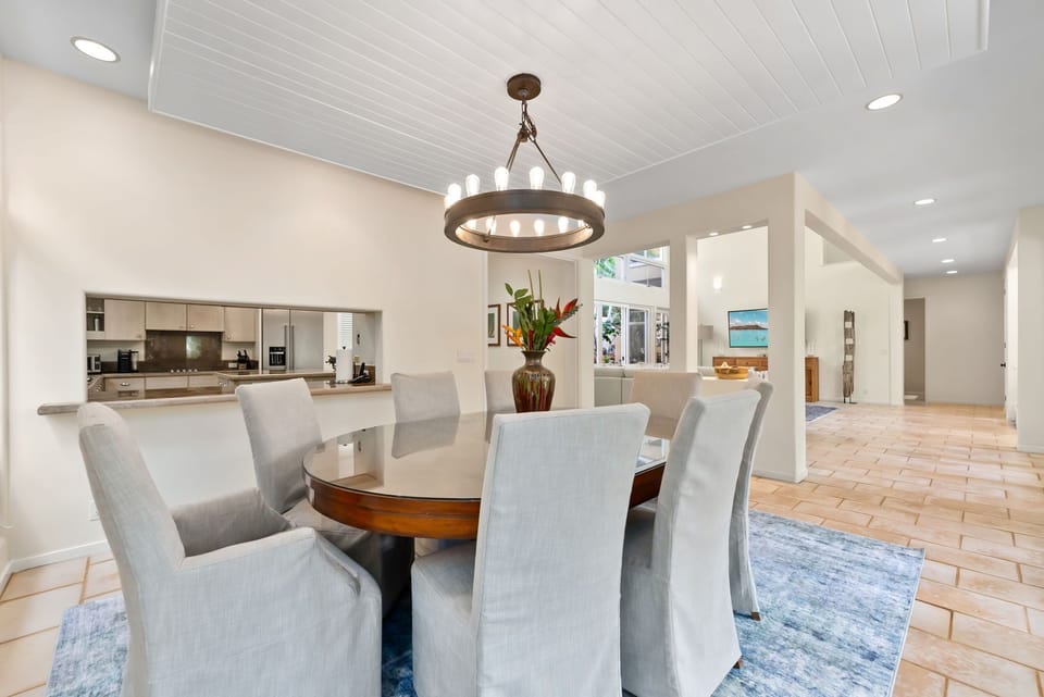 Gather around this elegant dining table where memorable meals await beneath stunning lighting and open-concept design.