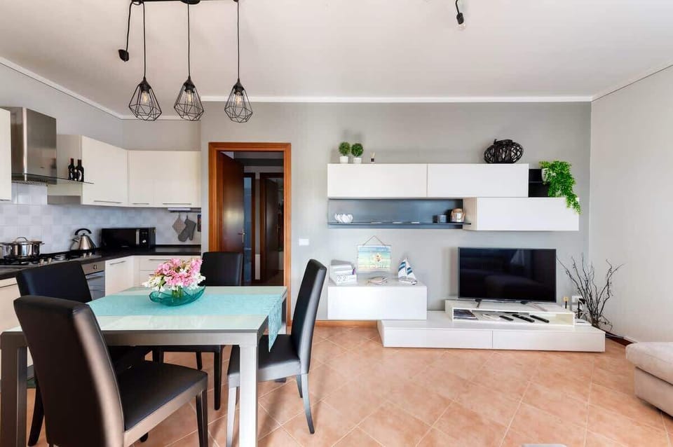 Area salotto con divano Poltrone&sofà, Pouff, Smart TV 43" e molto altro ancora, area pranzo con tavolo in vetro e sedie imbottite, area cucina con elettrodomestici