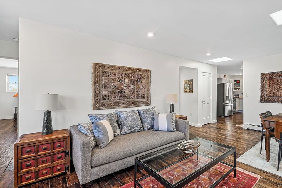 Unwind in your stylish living room featuring a plush sofa, warm hardwood floors, and curated artwork that creates the perfect atmosphere for relaxation.