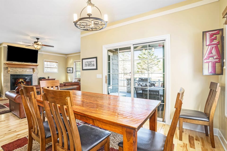 Dining area opening to the living room with a warm fireplace.