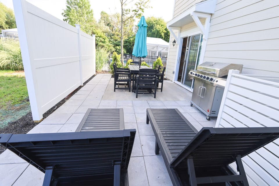 Enjoy a private patio with two lounge chairs, a full outdoor dining set, and a stainless- steel grill.