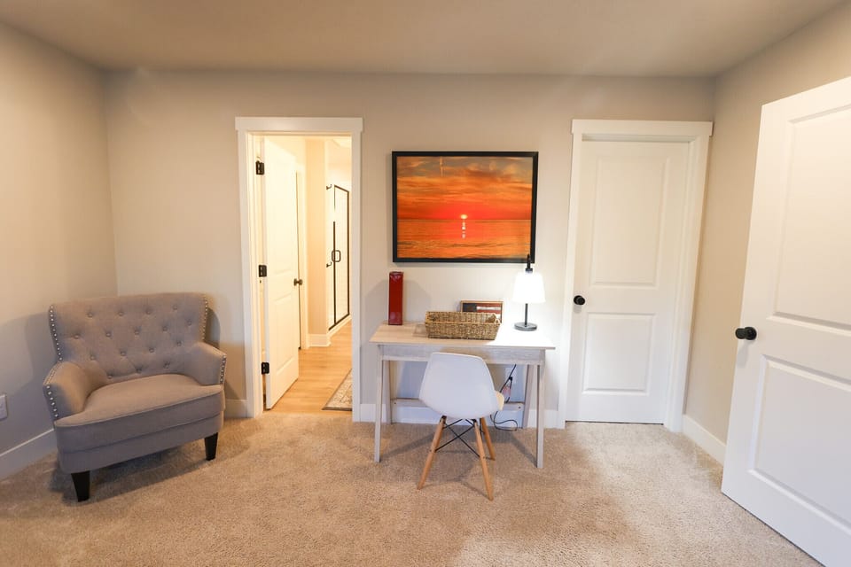 Bedroom sitting area offers a peaceful space to unwind, a comfortable armchair and a convenient writing desk.